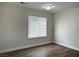 Minimalist bedroom with wood flooring, neutral walls, and large window providing natural light at 8010 Coffee Tree Ct, Las Vegas, NV 89123