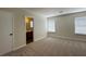 Bright bedroom featuring neutral carpet, two windows, and an ensuite bathroom at 8010 Coffee Tree Ct, Las Vegas, NV 89123
