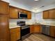 Updated kitchen with wooden cabinets, stainless steel appliances, and laminate countertops at 8010 Coffee Tree Ct, Las Vegas, NV 89123