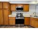 Well-lit kitchen with stainless steel microwave and oven, accompanied by warm wooden cabinetry at 8010 Coffee Tree Ct, Las Vegas, NV 89123