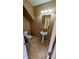 A half bathroom with pedestal sink, mirror and tile floors at 8159 Base Camp Ave, Las Vegas, NV 89178