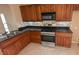 A kitchen featuring wood cabinets, stainless steel appliances, and granite countertops at 8159 Base Camp Ave, Las Vegas, NV 89178