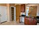 Kitchen sink and nearby walk-in pantry with shelves, wood cabinets and dark countertop at 8159 Base Camp Ave, Las Vegas, NV 89178