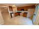 Kitchen with dark countertops, wooden cabinets, stainless steel sink, and tile floors at 8159 Base Camp Ave, Las Vegas, NV 89178