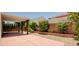 Covered patio and low-maintenance backyard landscape with decorative trees and bushes at 8159 Base Camp Ave, Las Vegas, NV 89178