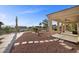 A backyard with a desert landscaped yard, covered patio, and beautiful greenery at 835 Market Crest Dr, Las Vegas, NV 89110
