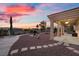 Backyard view with beautiful sunset, desert landscaping, and large covered patio at 835 Market Crest Dr, Las Vegas, NV 89110