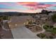 Beautiful home at twilight, showcasing its three-car garage, lush landscaping, and charming exterior details at 835 Market Crest Dr, Las Vegas, NV 89110
