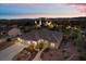 An aerial view of a well-maintained home with a landscaped yard and picturesque city lights in the background at twilight at 835 Market Crest Dr, Las Vegas, NV 89110