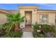 Charming home entrance with tile walkway, lush landscaping, and a secure alarm system at 835 Market Crest Dr, Las Vegas, NV 89110
