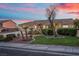 Attractive one-story home with manicured lawn and palm trees under a vivid sunset sky at 835 Market Crest Dr, Las Vegas, NV 89110