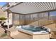 A backyard with an inviting hot tub under a wooden pergola surrounded by desert landscaping at 835 Market Crest Dr, Las Vegas, NV 89110