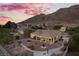 Spacious backyard with desert landscaping, covered patio, and breathtaking mountain views at dusk, ideal for relaxation at 835 Market Crest Dr, Las Vegas, NV 89110