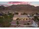 Beautiful backyard featuring a covered patio, desert landscaping, and impressive mountain views at sunset at 835 Market Crest Dr, Las Vegas, NV 89110