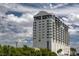 Exterior view of the building against a cloudy sky with lush trees in the foreground at 900 Las Vegas Blvd # 1003, Las Vegas, NV 89101