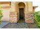 Close-up of the home's entrance featuring an arched entryway, decorative door, and stone accents at 9025 Rusty Rifle Ave, Las Vegas, NV 89143