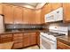A well-lit kitchen featuring wooden cabinets and modern white appliances at 9025 Rusty Rifle Ave, Las Vegas, NV 89143
