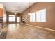 Spacious living area with tiled flooring, large windows, and a partial view of the kitchen at 9025 Rusty Rifle Ave, Las Vegas, NV 89143