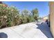 Spacious concrete backyard with flowering bushes and a patio set at 9428 Sierra Summit Ave, Las Vegas, NV 89134