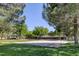 Serene community park featuring lush green grass, mature trees, a picnic pavilion, and a sand volleyball court at 9428 Sierra Summit Ave, Las Vegas, NV 89134