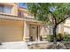 Inviting two-story home with a tan exterior, a well-manicured lawn, and an attached garage at 9428 Sierra Summit Ave, Las Vegas, NV 89134