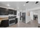 Modern kitchen with dark cabinets, granite countertops, stainless appliances, and a pass-through to dining at 9428 Sierra Summit Ave, Las Vegas, NV 89134