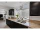 Close up of a kitchen featuring granite countertops, stainless steel sink and dark cabinetry at 9428 Sierra Summit Ave, Las Vegas, NV 89134
