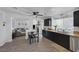 Modern kitchen featuring dark cabinets, granite countertops, stainless steel appliances, and a dining area at 9428 Sierra Summit Ave, Las Vegas, NV 89134