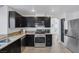 Updated kitchen featuring stainless appliances, dark cabinetry, granite counters, and modern fixtures at 9428 Sierra Summit Ave, Las Vegas, NV 89134