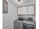Modern laundry room with front-load washer and dryer and white cabinets at 9428 Sierra Summit Ave, Las Vegas, NV 89134