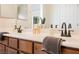 Bathroom with double sink vanity, warm wood cabinets, and modern fixtures at 9490 Thunder Sky St # 102, Las Vegas, NV 89178