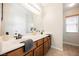 Bathroom with double sink vanity, warm wood cabinets, and modern fixtures at 9490 Thunder Sky St # 102, Las Vegas, NV 89178