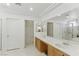 Bright bathroom featuring double sinks, a large mirror, and a glass-enclosed shower at 9785 Turtle Head Ct, Las Vegas, NV 89117