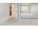 Vacant bedroom with light colored carpet, sliding mirror closet door, and entry to hallway and laundry room at 9785 Turtle Head Ct, Las Vegas, NV 89117