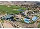 Aerial view of a country club, featuring pools, tennis courts, and a well-manicured golf course at 1 Costa Del Sol Ct, Henderson, NV 89011