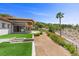 Expansive backyard featuring lush landscaping, a gravel walkway, and a glimpse of the home's architecture at 1 Costa Del Sol Ct, Henderson, NV 89011