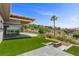 Expansive backyard features an immaculate lawn, desert landscaping, and an open-air patio with sliding glass doors at 1 Costa Del Sol Ct, Henderson, NV 89011