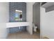 Modern bathroom featuring a unique geometric tile wall, floating vanity, and stylish fixtures at 1 Costa Del Sol Ct, Henderson, NV 89011