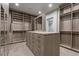 Spacious walk-in closet with custom shelving, drawers, and a central island at 1 Costa Del Sol Ct, Henderson, NV 89011