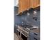 Modern kitchen with a stainless steel range, cooktop, gray cabinetry, and marble countertops at 1 Costa Del Sol Ct, Henderson, NV 89011
