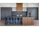 Modern eat-in kitchen featuring a large island, gas cooktop, stainless steel appliances, and dark cabinets at 1 Costa Del Sol Ct, Henderson, NV 89011