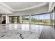 Open-concept living room with floor-to-ceiling windows, marble floors, and stunning mountain views at 1 Costa Del Sol Ct, Henderson, NV 89011
