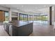 Open-concept kitchen and living room with a large island, access to the backyard, and mountain views at 1 Costa Del Sol Ct, Henderson, NV 89011