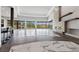 Spacious open-concept living area with tile floors, a stone fireplace, and expansive glass windows at 1 Costa Del Sol Ct, Henderson, NV 89011