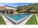 Backyard view of a luxurious pool surrounded by lush greenery and a well-manicured lawn at 1 Costa Del Sol Ct, Henderson, NV 89011