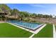 Beautiful backyard pool area with a pristine pool, surrounded by green lawn and mature trees at 1 Costa Del Sol Ct, Henderson, NV 89011
