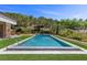 Modern rectangular pool with spa, set against a backdrop of mature trees and greenery in the backyard at 1 Costa Del Sol Ct, Henderson, NV 89011