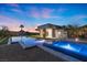 Inviting backyard oasis featuring a modern pool, spa, and outdoor living space with mountain views at sunset at 1 Costa Del Sol Ct, Henderson, NV 89011