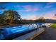 Beautiful backyard with a modern pool, spa, patio and desert views at dusk at 1 Costa Del Sol Ct, Henderson, NV 89011