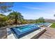 A dazzling pool and jacuzzi combo, with a backdrop of scenic mountains and a lush palm tree at 1 Costa Del Sol Ct, Henderson, NV 89011
